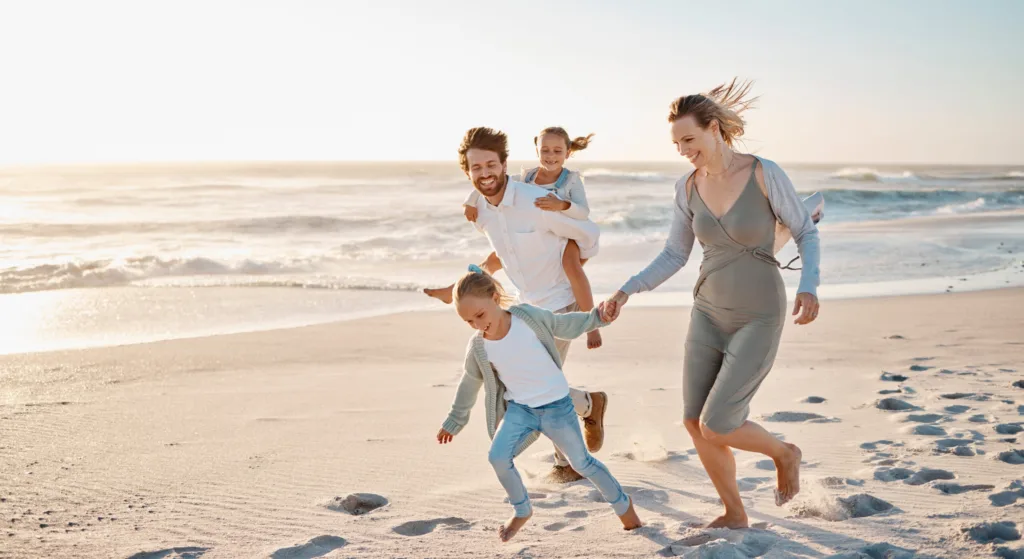 Famille courant sur la plage au coucher du soleil, prévoyance des travailleurs indépendants